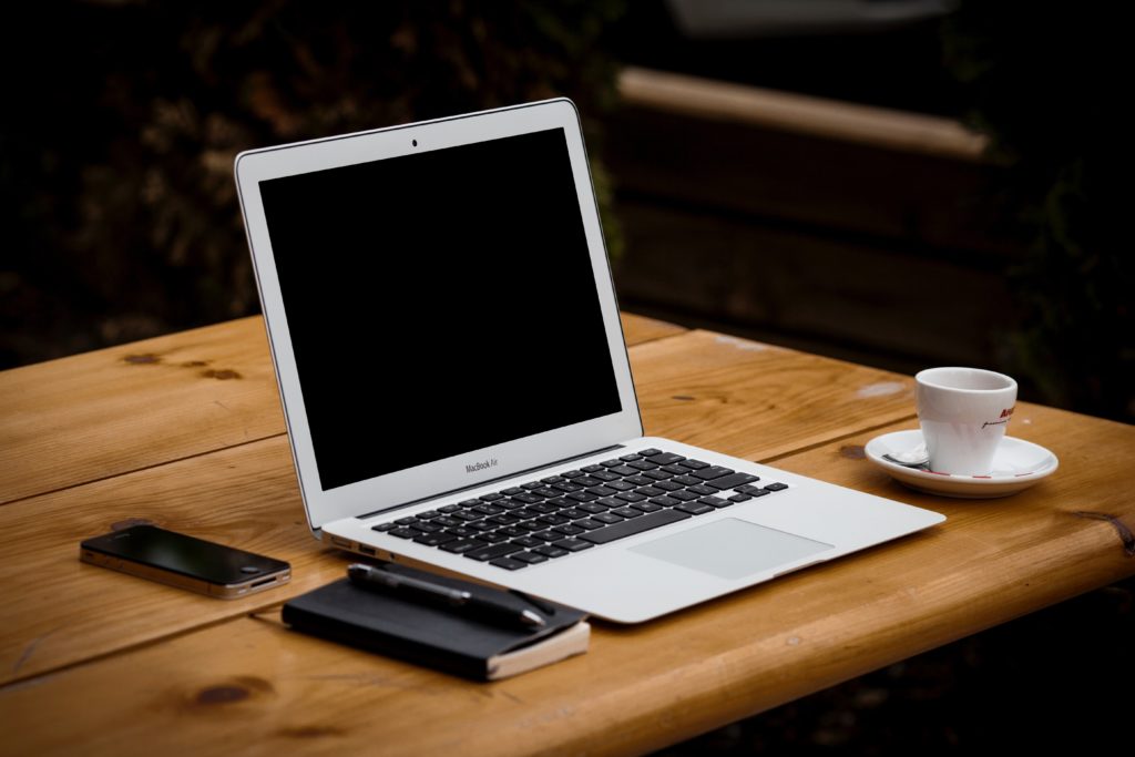 laptop moleskine iphone and espresso on wooden table